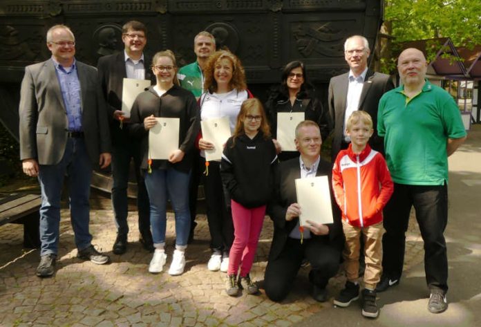 Ehrende sowie Vertreter der Gewinner-Vereine (von links): Stefan Leim (Vorsitzender der Sportjugend Pfalz), Herbert Schwarzmüller (ASV Lug/Dimbach), Marie Holländer (TPSV Enkenbach), Christian Keiser (VfR Sondernheim), Dr. Martina Schott (Rudergesellschaft Speyer), Anja Marx (1. FFC Niederkirchen), Dr. Benjamin Krenberger (kniend, VT Zweibrücken mit zwei Kindern), Matthias Johann (Bezirksverband Pfalz), Reinhard Tenzer (AOK Rheinland-Pfalz/Saarland) (Foto: Bezirksverband Pfalz)