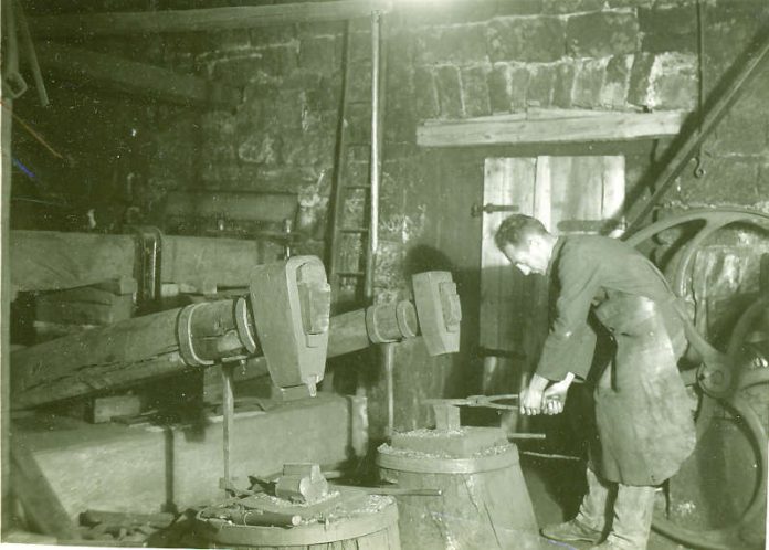 Historisches Foto )Ende der 20er Jahre): der letzte Hammerschmied Heinrich Haag am Amboss (Archiv Förderverein, Gemeinde, Siebein).