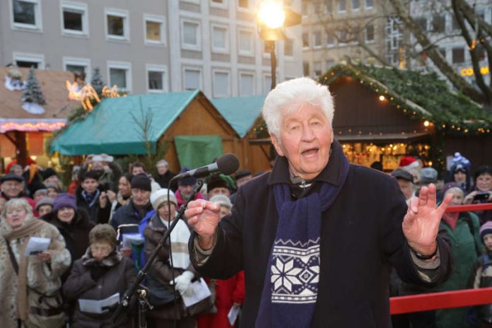 Zum Weihnachtssingen gastiert Gotthilf Fischer am Nikolaustag auf dem Karlsruher Christkindlesmarkt und verteilt den weltgrößten Dambedei an die Besucherinnen und Besucher. (Foto: Stadt Karlsruhe) Zum Weihnachtssingen gastiert Gotthilf Fischer am Nikolaustag auf dem Karlsruher Christkindlesmarkt und verteilt den weltgrößten Dambedei an die Besucherinnen und Besucher. (Foto: Stadt Karlsruhe)