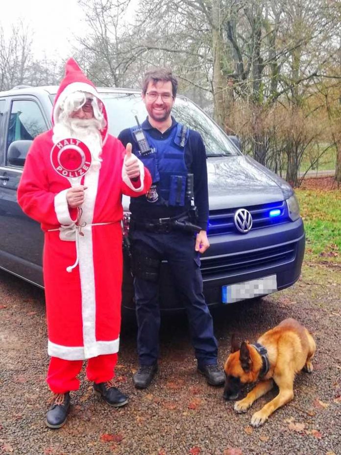 Weihnachtsmann und Polizeihundeführer mit Diensthund Dzuba
