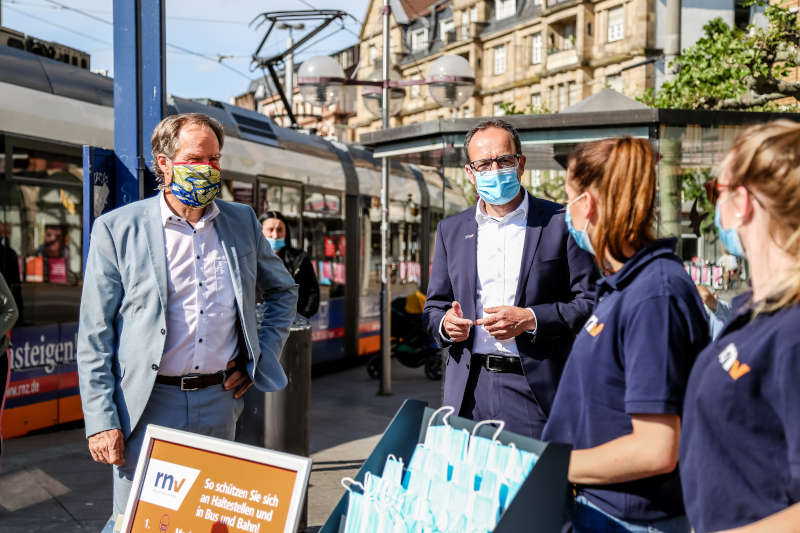 Maskenverteilaktion am Bismarckplatz: Am ersten Tag der deutschlandweiten Maskenpflicht weisen Heidelbergs Oberbürgermeister Prof. Dr. Eckart Würzner und der Kaufmännische Geschäftsführer der rnv, Christian Volz, gemeinsam mit rnv-Promoterinnen (v.l.) auf das Tragen von Mund- und Nasenbedeckung im ÖPNV hin. (Foto: Pellner/ Stadt Heidelberg)