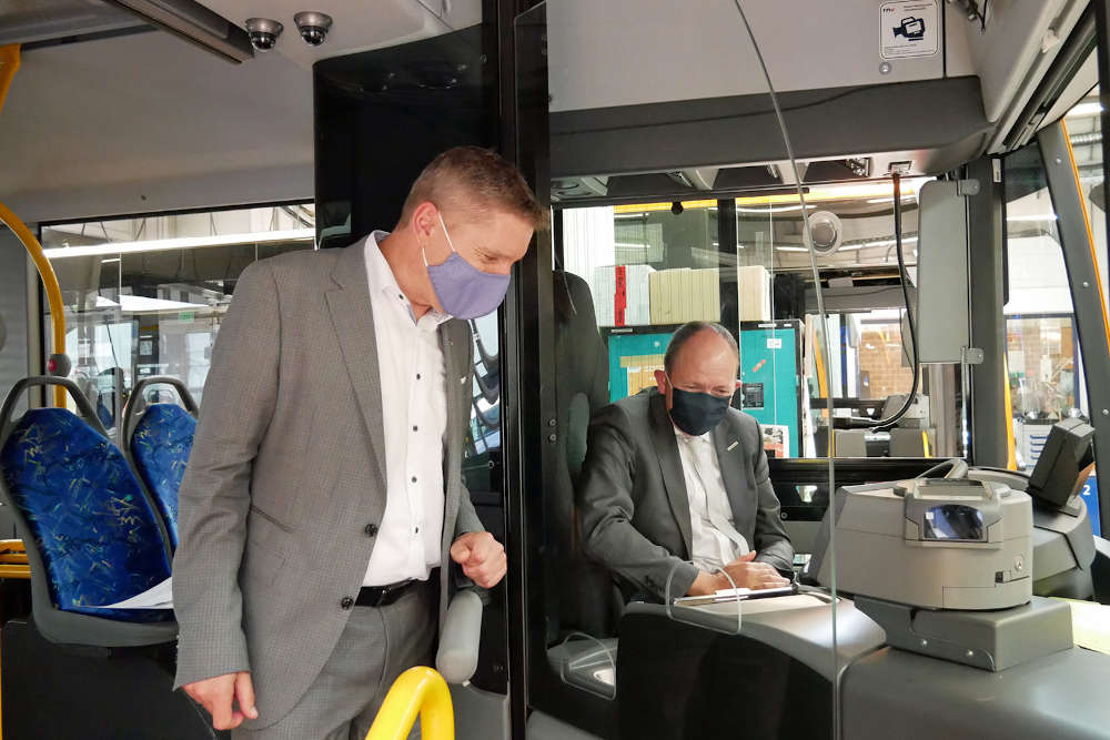 Martin in der Beek, Technischer Geschäftsführer der rnv, und Christian Specht, Aufsichtsratsvorsitzender der rnv, in einem Bus, in dem eine neue Glastrennscheibe verbaut wurde. (Foto: rnv GmbH)