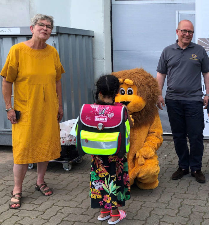 Zusammen mit Maskottchen Leo vom Lions Club starteten Gabriela Plohmann, Karlsruher Tafel e.V. und Tobias Höltzel, Lions Club Karlsruhe-Schloss die Schulranzen-Aktion 2020 (Foto: Lions Club Karlsruhe-Schloss)