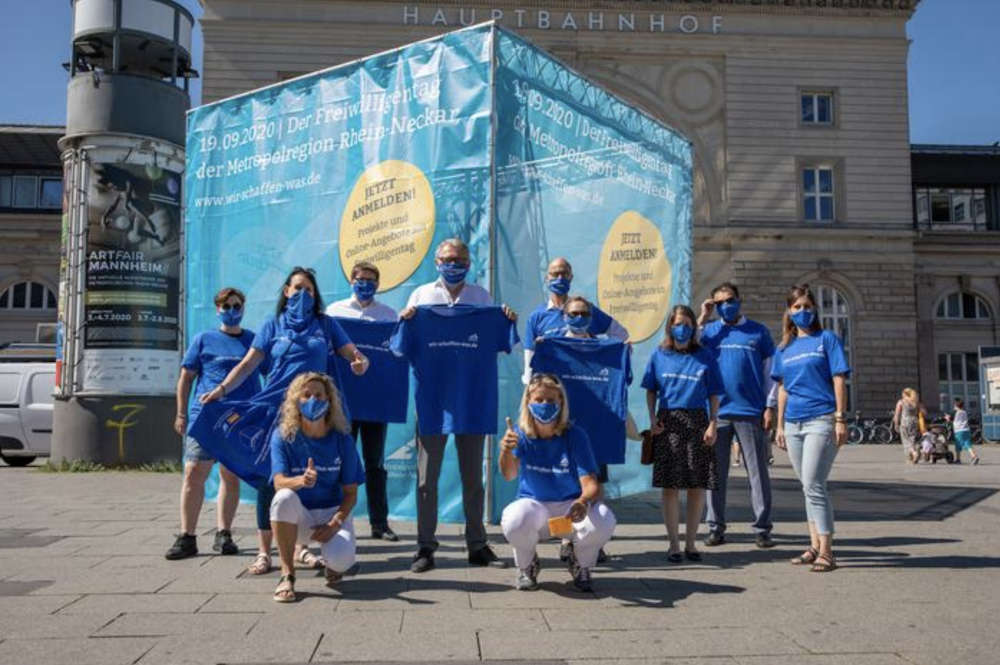 Der blaue Riesenwürfel am Willy-Brandt-Platz vor dem Mannheimer Hauptbahnhof fällt auf! Drei soziale Einrichtungen, der Zentrale Lehrgarten Mannheim und das TECHNOSEUM in Mannheim werben gemeinsam mit Oberbürgermeister Dr. Peter Kurz und Kirsten Korte, Geschäftsführerin, Zukunft Metropolregion Rhein-Neckar e.V. bei einem Fototermin rund um den Würfel für ein Engagement beim Freiwilligentag der Metropolregion Rhein-Neckar, der unter dem Motto „Wir schaffen was!“ am Samstag den 19.09.2020 stattfindet. (Foto: MRN GmbH/Go7)