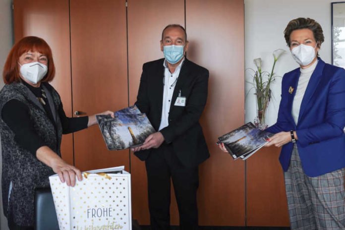 Marion Schulz-Reese (l.) und Ursula Ritter (r.) überreichen Peter Förster die Adventskalender