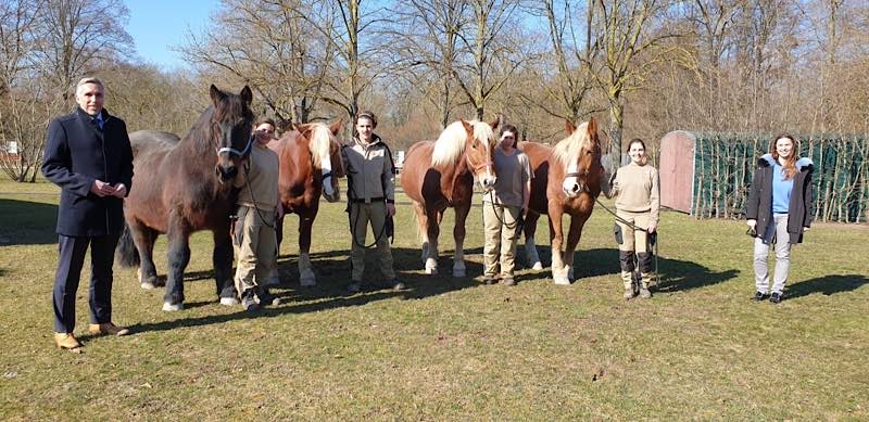 Tierisch gut drauf: Denn es geht wieder los – bereits nach wenigen Stunden waren fast alle Besuchertickets bereits vergriffen. Beigeordneter Uwe Franz, Geschäftsführerin Nina Scharer und das Tiergarten-Team nebst den imposanten Süddeutschen Kaltblütern begrüßen die ersten Besucher. (Foto: Tiergarten Worms gGmbH, Nina Hochstrasser)