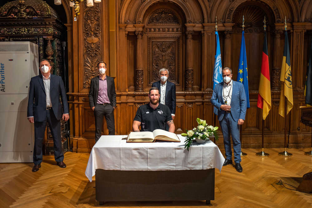 Eintrag in das Goldene Buch der Stadt Heidelberg: Phillipp Heyden, Kapitän der MLP Academics Heidelberg (sitzend), gemeinsam mit Trainer Branislav Ignjatovic, Geschäftsführer Matthias Lautenschläger, Unterstützter und Sponsor Dr. Manfred Lautenschläger und Oberbürgermeister Prof. Dr. Eckart Würzner (von links). (Foto: Tobias Dittmer)