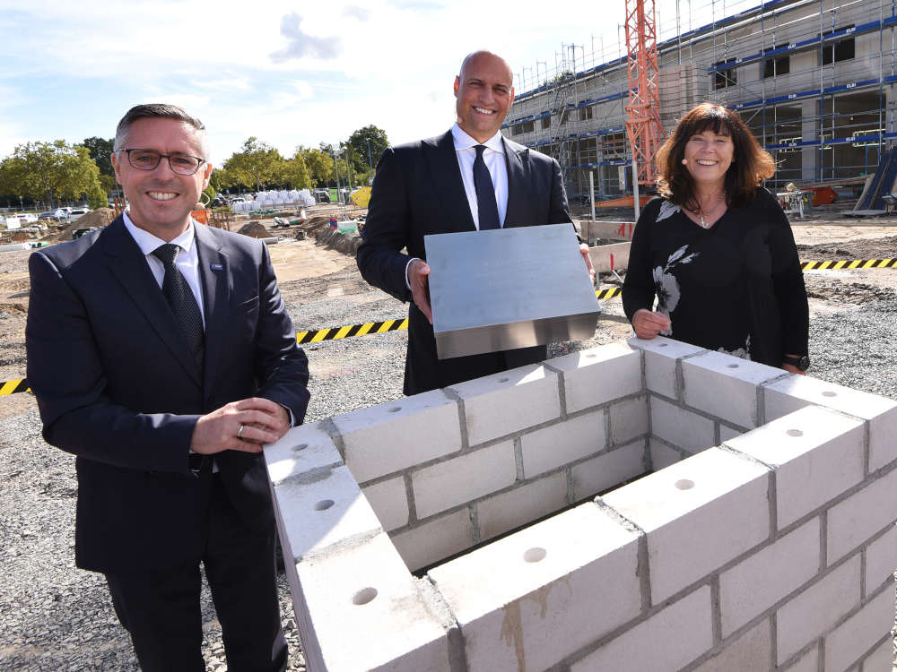 Dr. Dennis Fanelsa, Leiter Site Management Ludwigshafen, Jutta Steinruck, Oberbürgermeisterin von Ludwigshafen und Prof. Dr. Christoph Oberlinner, Chief Medical Officer der BASF, befüllten eine Zeitkapsel unter anderem mit einem Werks- und einem Bauplan, einer aktuellen Tageszeitung und einer Schutzmaske. (Foto: BASF / Marcus Schwetasch)