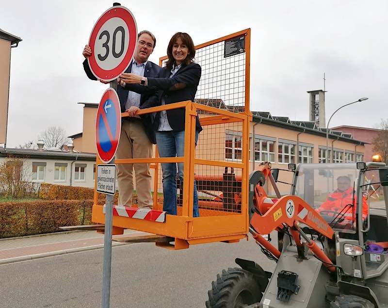 Schulleiterin Nicole Ihrig und Bürgermeister Tobias Meyer beim Anbringen des neuen Geschwindigkeitsbegrenzungsschildes zeigt (aufgenommen Mitte November). (Foto: Gemeindeverwaltung Haßloch)