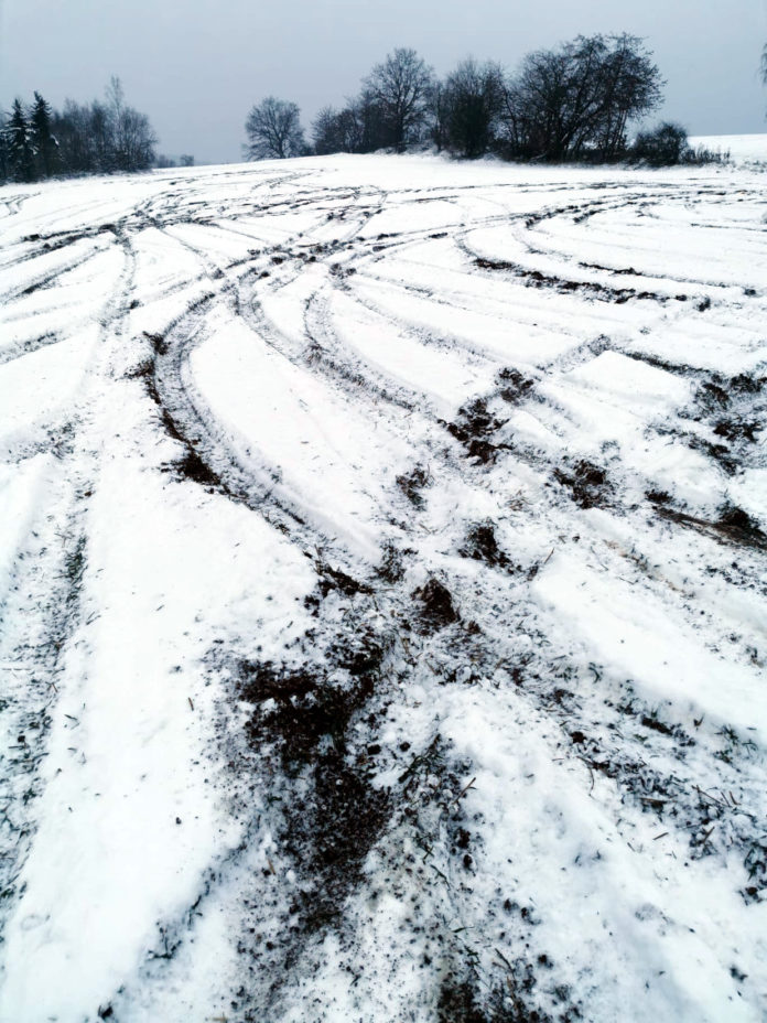 Zerstörtes Feld mit Fahrspuren