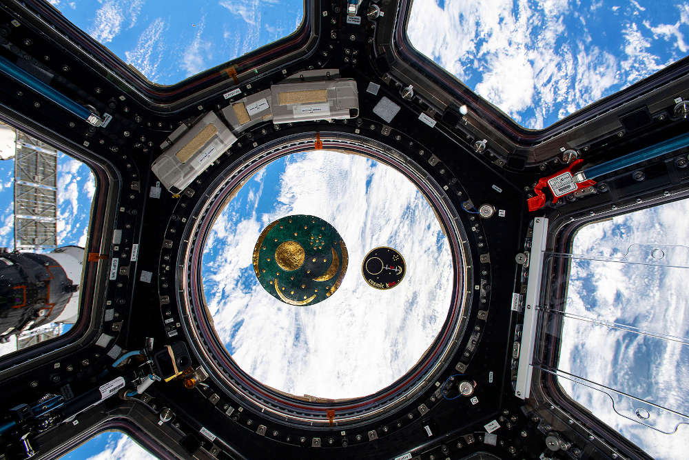 Wie ei­ne Mi­ni-Ver­si­on schwebt das Patch der „Cos­mic Kiss“-Missi­on von Mat­thi­as Mau­rer ne­ben ei­ner Ko­pie der Him­mels­schei­be von Ne­bra in der Aus­sichts­platt­form Cu­po­la auf der In­ter­na­tio­na­len Raum­sta­ti­on ISS. In­spi­riert von der 3600 Jah­re al­ten Him­mels­schei­be re­prä­sen­tiert das „Cos­mic Kiss“-Mission­patch die be­son­de­re Ver­bin­dung, die die Raum­sta­ti­on zwi­schen den Be­woh­nern der Er­de und dem Kos­mos her­stellt. (Foto: NASA/ESA-M.Maurer)