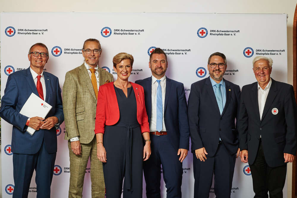 Oberin Wagner und Ehrengäste, v. l. n. r.: Präsident Michael Burkert des DRK Landesverbandes Rheinland-Pfalz, Comedian CHAKO Habekost, Oberin Heike Diana Wagner, Staatsekretär Fedor Ruhose aus dem Ministerium für Arbeit, Soziales, Transformation und Digitalisierung von Rheinland-Pfalz, Oberbürgermeister Marc Weigel, Präsident des DRK Landesverbandes des Saarlandes. (Foto: DRK Schwesternschaft Rheinpfalz-Saar/Hardy Mueller)