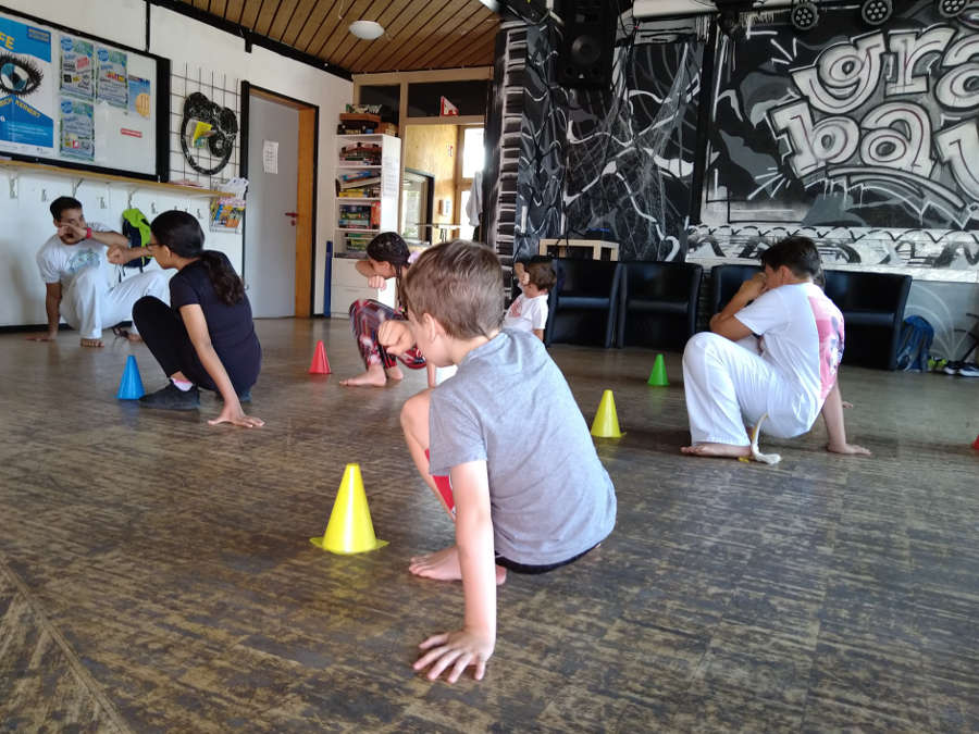 Der Capoeira-Trainer Cao zeigt den Kindern im Ferienprogramm die sogenannte „Cocorinha“, eine Ausweichbewegung (Foto: Dana Graulich)