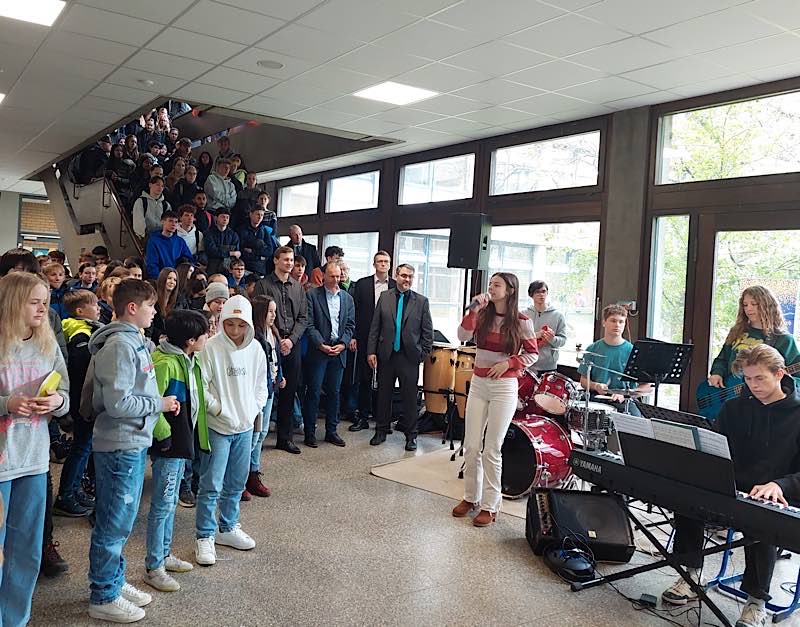 Die Bigband des Gymnasiums sorgte mit kraftvollen Liedern für einen feierlichen Rahmen. Gespielt wurde in der Pause, damit die Schülerinnen und Schüler bei der offiziellen Übergabe durch OB Weigel (Mitte) dabei sein konnten. (Foto: Stadtverwaltung Neustadt)