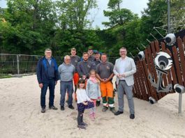 OB Marc Weigel (re.) mit Mitarbeitern der Abteilung Grünflächen, die den neuen Spielplatz gebaut haben. Ganz rechts Grünflächenchef Michael Fuhrer. Anastasia und Charlotte waren die ersten Besucherinnen und vom neuen Spielplatz begeistert. (Foto: Stadtverwaltung Neustadt)