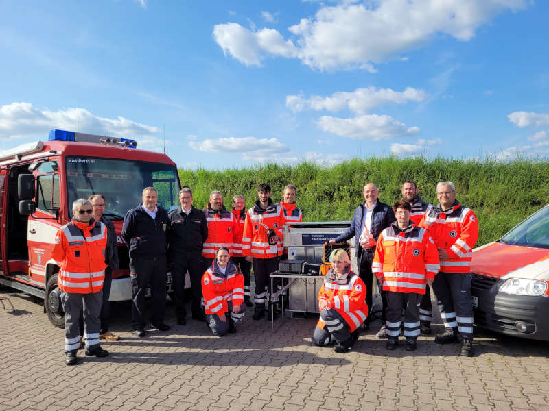 Kreisbeigeordneter Sven Hoffmann (4. v.r.) und Brand- und Katastrophenschutzinspekteur Sascha Schwenk (3. v.l.) bei der Übergabe der Ausrüstung mit Mitgliedern des DRK. (Foto: Kreisverwaltung Bad Dürkheim)