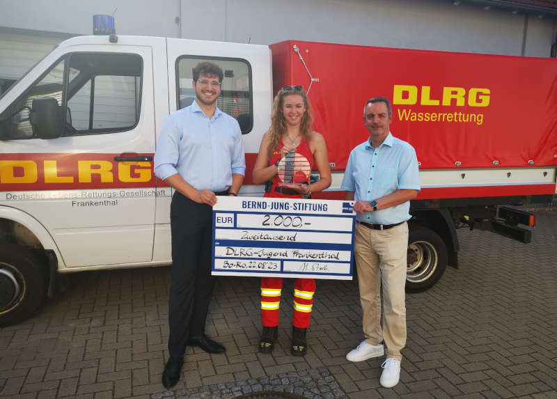 Harald Stark, Geschäftsführer der Stiftung (rechts) und Vorstandsmitglied Julian Geib (links) übergeben den Stiftungspreis an Selina Vieten, Vorstandsmitglied der DLRG Frankenthal. (Foto: Bernd-Jung-Stiftung)