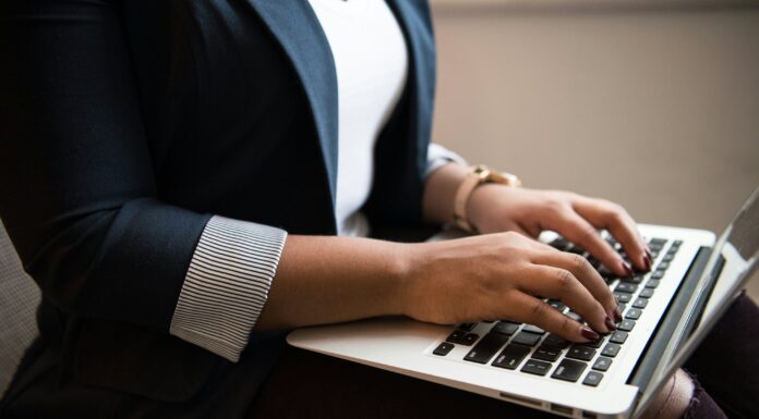 Brand Mentions vs Backlinks: Was ist in Zukunft wichtiger? Frau sitzt und benutzt Laptop auf ihrem Schoß ( Christina @ wocintechchat.com / Unsplash)