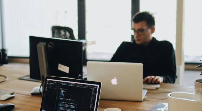 Logistik im Wandel: Herausforderungen und moderne Lösungen Mann Im Schwarzen Hemd Sitzt Hinter Schreibtisch Mit Computern (Pexels / Djordje Petrovic)