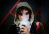 Junger Mann, der eine Vape dampft