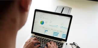 Person analysiert Finanzdaten und Diagramme auf einem Laptop – Symbolbild für Schuldenberatung und finanzielle Planung.