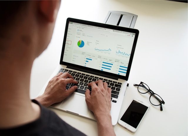 campaign-creators-pypeCEaJeZY-unsplash (1) Person analysiert Finanzdaten und Diagramme auf einem Laptop – Symbolbild für Schuldenberatung und finanzielle Planung.